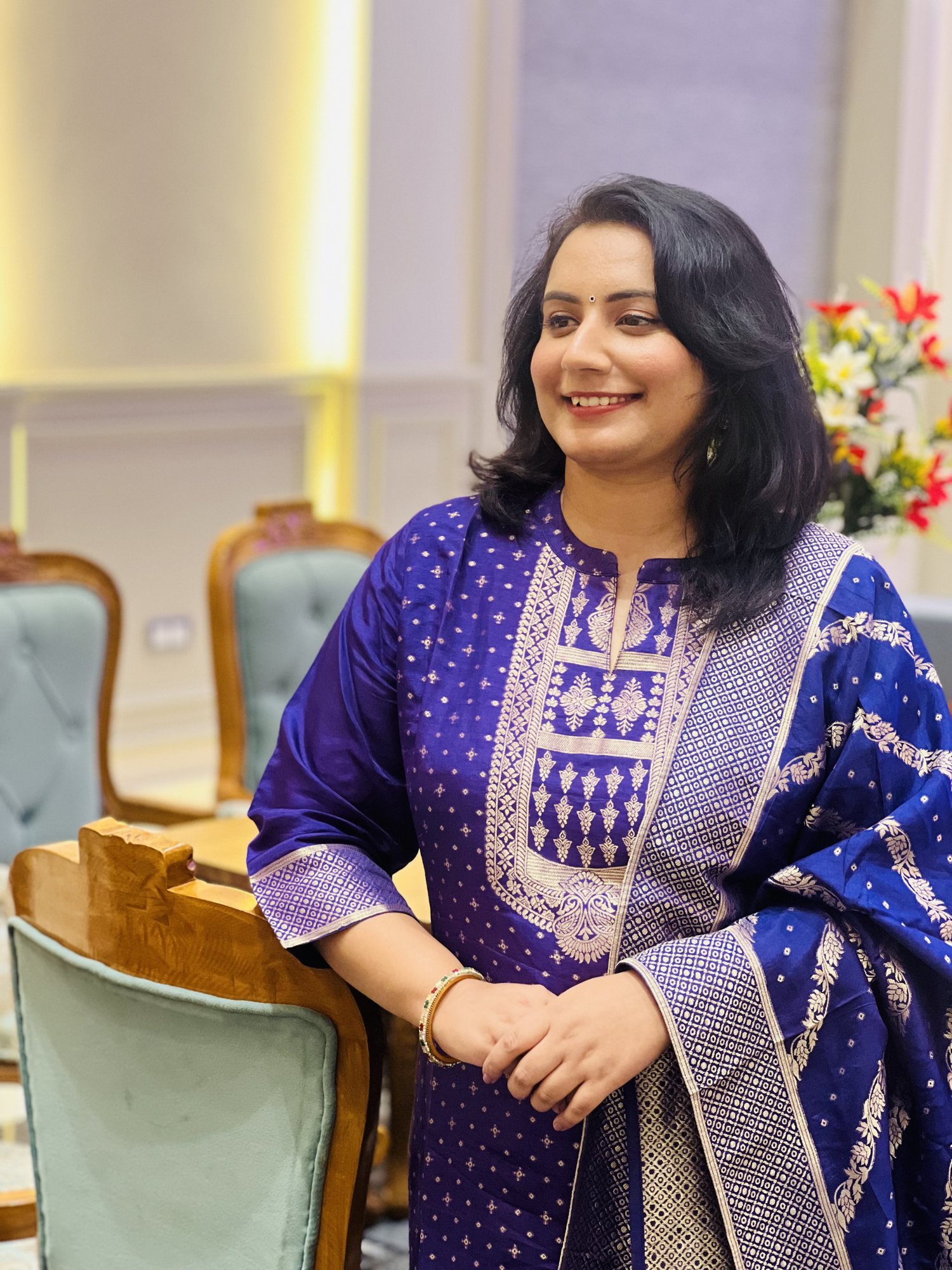Dr Kashish (Kashissh Khatrii), money manifestation coach, smiling in a blue suit